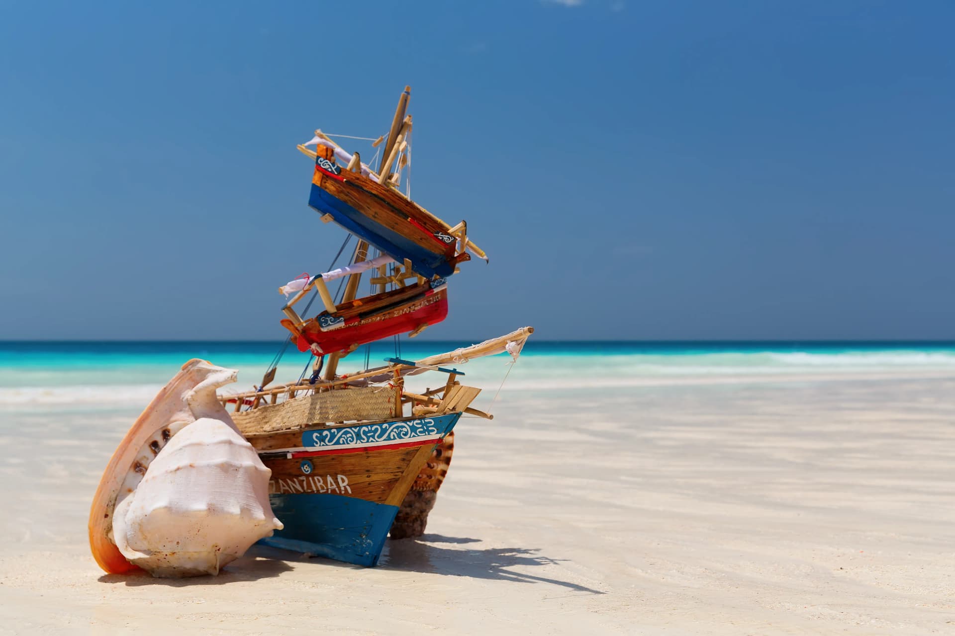 Zanzibar beach — traditional dhow boat on white sand